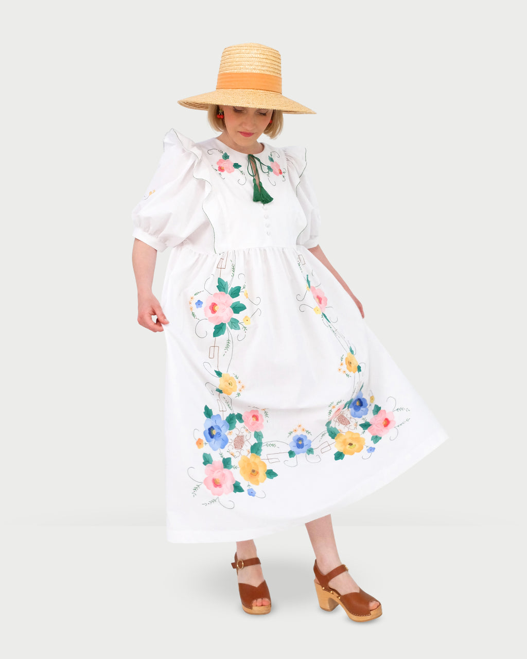 Robe babydoll blanche longueur maxi, manches bouffantes et fleurs multicolores brodées à la main.